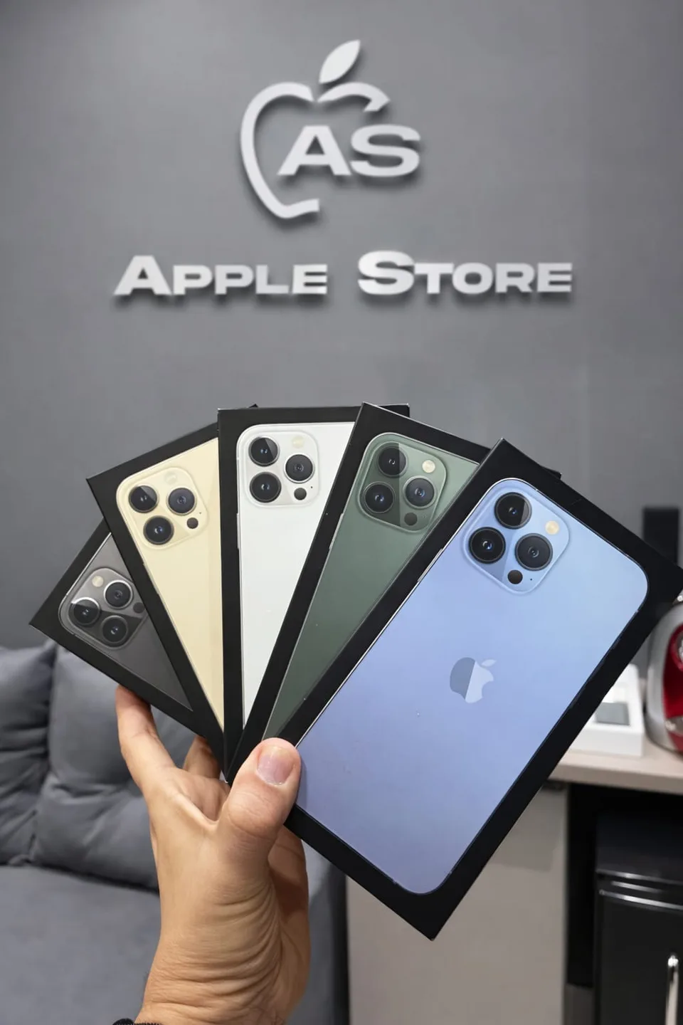 Cajas de distintos iPhone frente al logo de la tienda
